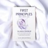 The image shows a book titled "FIRST PRINCIPLES Sleep - Breath - Heal" laid flat on a soft, white, ruffled fabric background. The cover features a graphic of a brain with connecting lines and nodes, in shades of purple and blue. Below the title, there is a subtitle "THE HEALTH CONTINUUM" followed by a brief explanation: "How a small problem in early life creates havoc across time." The author's name, "Scott Wustenberg," is printed at the bottom of the cover. The book's cover design is minimalist with a focus on the central brain illustration, suggesting a scientific or medical theme related to the topics of sleep, breathing, and healing.